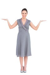 Cheerful elegant woman in classy dress posing hands up