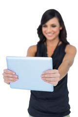 Fototapeta premium Smiling elegant brown haired model looking at her tablet pc