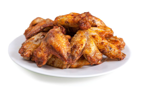 Plate of delicious barbecue chicken wings, on white