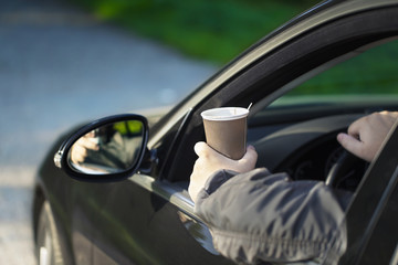 Man with coffee in car