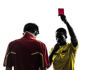 Obraz premium two men soccer player and referee showing red card silhouette