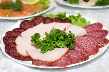 Cutting sausage and cured meat on a celebratory table
