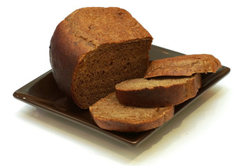 Black bread cut into slices lying on a brown platter