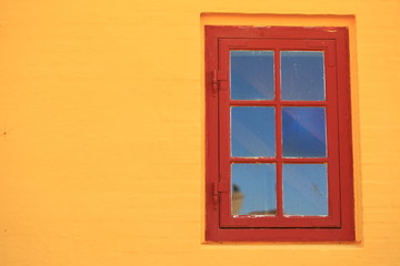 Obraz na płótnie Canvas red window on orange wall architecture detail