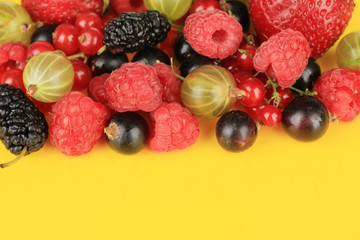 Ripe berries on yellow background