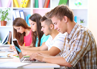 Group of young students sitting at the library