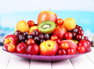 Naklejka na ściany i meble Assortment of juicy fruits on wooden table, on bright