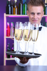 Bartender holding tray with champagne glasses