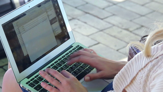 Laptop screen young woman hands type letter e-mail in park
