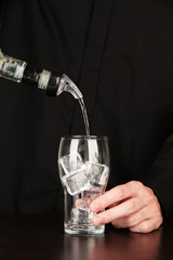 Bartender making cocktail on bright background, close-up