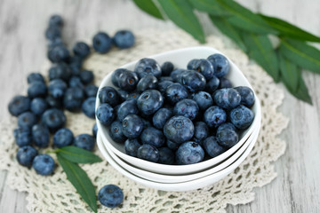 Blueberries in plates on napkin on wooden background