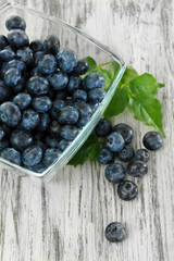 Blueberries in glass bowl on wooden table