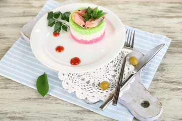 Colored rice on plate on board on napkin on wooden table