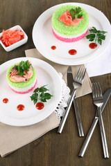 Colored rice on plates on napkins on wooden table