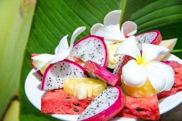 Früchteteller mit Ananas, Melone, Drachenfrucht und Fragipanis - 55699323