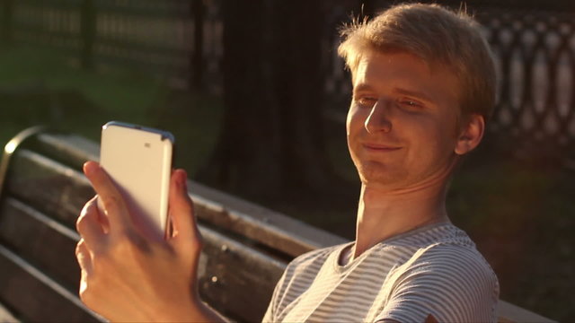 Funny blond man taking photo himself in park for social