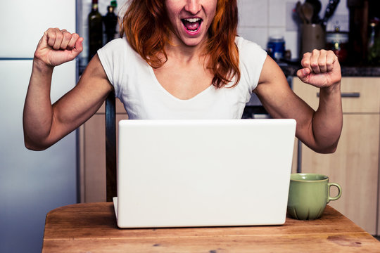 Woman at home is very excited about her laptop