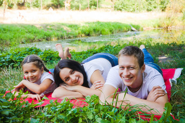 Fototapeta premium Family lying on a red blanket