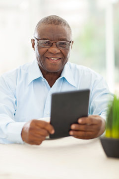 senior african man holding tablet computer