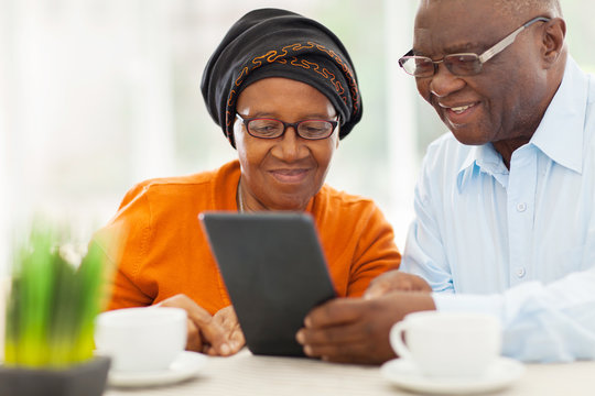 elderly african couple using tablet computer