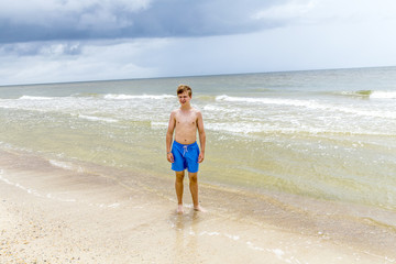 young happy boy looking handsome at the beach