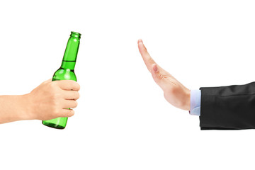 Man in suit refusing a bottle of beer