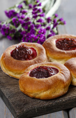 Obraz na płótnie Canvas Round buns with plum on wooden table