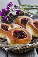 Round buns with plum on wooden table