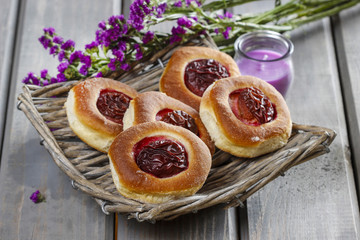 Round buns with plum on wooden table