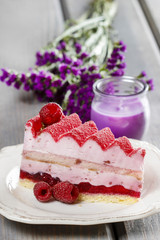 Pink layer cake decorated with fresh fruits on wooden table