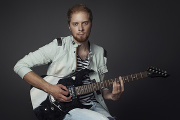 the guy with the red beard playing a guitar