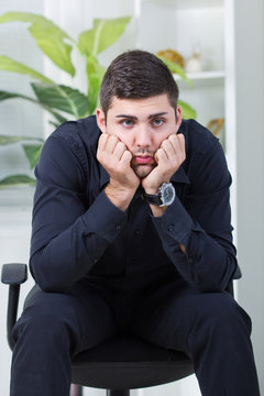 businessman sitting in a chair worried about too much work