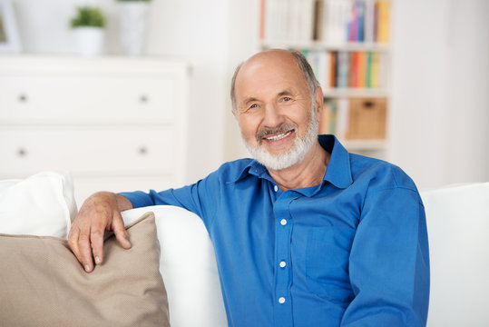 &auml;lterer mann sitzt entspannt auf dem sofa