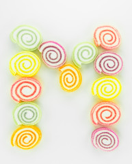 Letter M written with slices of dried sweet candies