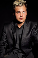 Obraz premium Elegant young handsome man over dark. Studio fashion portrait.