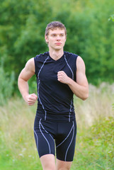 Handsome sportsman running in park