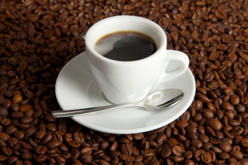 Cup of coffee on coffee beans background