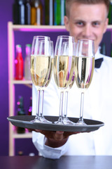 Bartender holding tray with champagne glasses