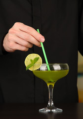 Bartender making and decorating cocktail on close-up