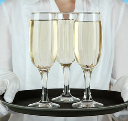 Waitresses holding tray with glasses of champagne