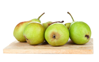 Pears on wooden cutting board, isolated on white