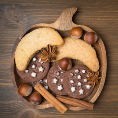 cookies, spices and nuts on a wooden plate