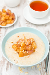 oatmeal with caramelized peaches and tea for breakfast, top view