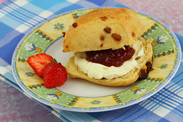 Scone with strawberry jam and clotted cream, close up
