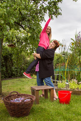 Woman with girl picking plums