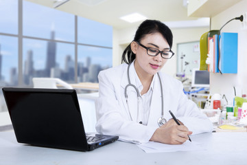Beautiful doctor write prescription at clinic