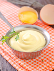 mayonnaise in metal spoon on wooden board