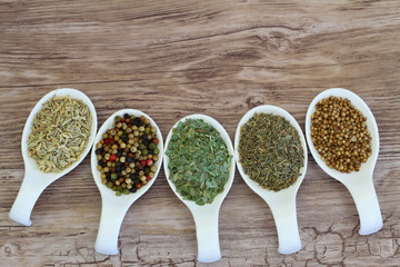 Selection of herbs and spices on spoons with copy space