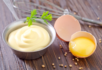 mayonnaise in metal spoon on wooden board