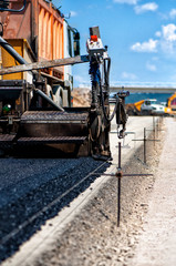 Fototapeta premium Industrial pavement truck or machine laying fresh bitumen